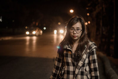 Woman standing on street at night