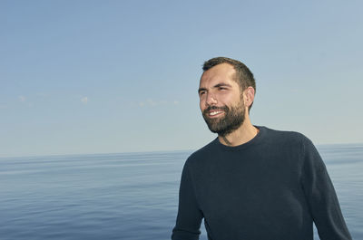 Portrait of man standing against sea