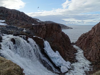 Scenic view of rocks in sea against sky