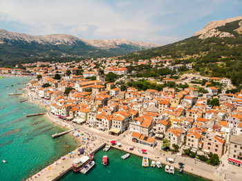 High angle view of townscape by sea against sky