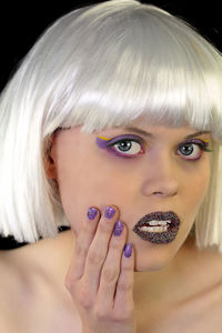 Close-up portrait of young woman in purple make-up