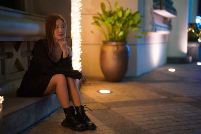 Portrait of young woman sitting on floor