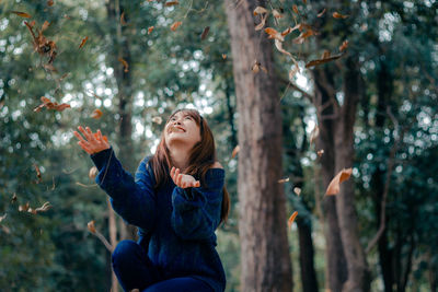 Young woman looking away in forest