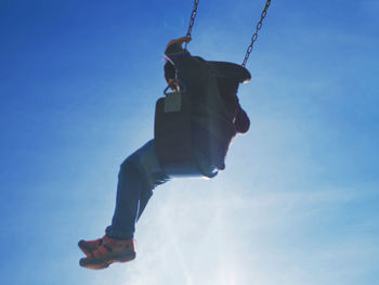 Low angle view of swinging boy