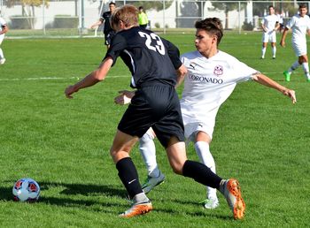 Men playing soccer on field