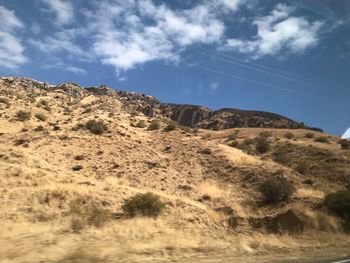 Low angle view of arid landscape against sky