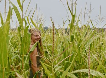 Portrait of smiling woman standing by plants