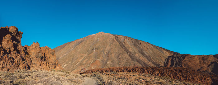 View of mountain range against blue sky