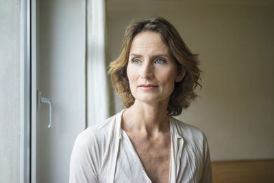 Portrait of pensive mature woman at the window