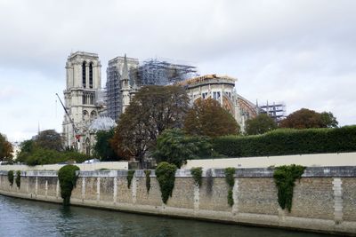 Built structure by river against sky in city