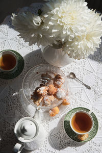 English style tea break, still life with flowers and donuts in the morning sun