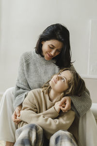 Daughter and mother looking at each other in living room