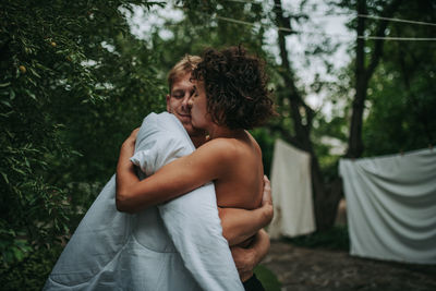 Couple standing against trees