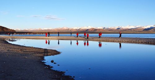 People on beach against blue sky