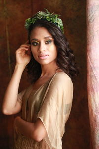 Portrait fashion model standing against backdrop