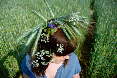 High angle view of plants on woman head in farm during sunny day