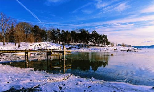 Scenic view of lake against sky during winter