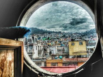 View of cityscape against cloudy sky