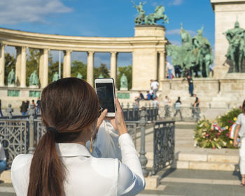 Asian tourist take photo with phone from the millennium monument