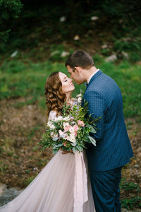 Rear view of man and woman holding flower