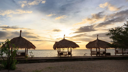 Gazebo on beach against sky during sunset