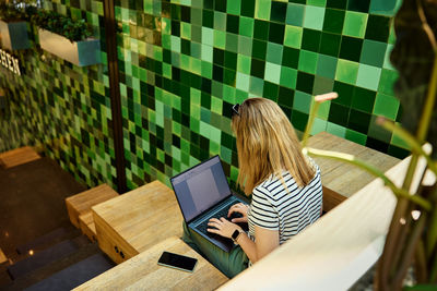 Woman using laptop in coworking. female freelancer typing on laptop keyboard. online work in cafe