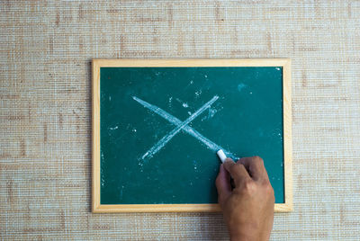 Directly above shot of cropped hand drawing on slate