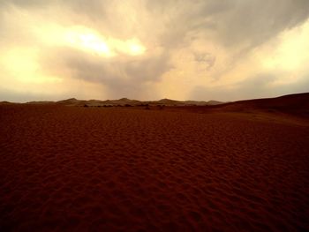 Scenic view of desert against sky during sunset
