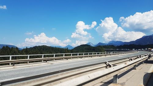 Road by mountains against sky