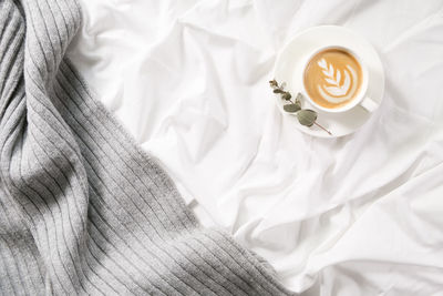 High angle view of coffee cup on bed