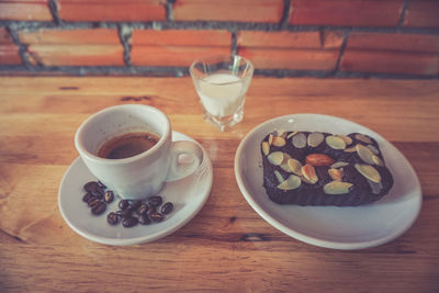 High angle view of coffee cup and dessert on table