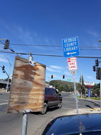 Information sign on road against blue sky