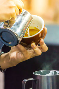 Close-up of hand holding coffee cup