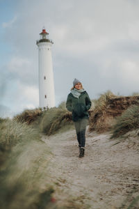 Woman walking against lighthouse during winter
