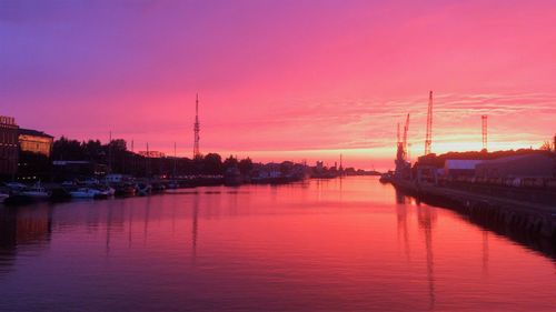 View of boats moored in river at sunset