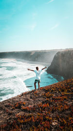 Man standing at beach against sky