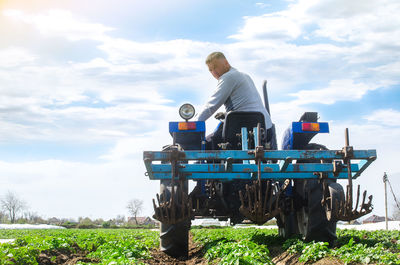 A farmer rides a tractor across the field and looks back. agricultural farm field cultivation. 