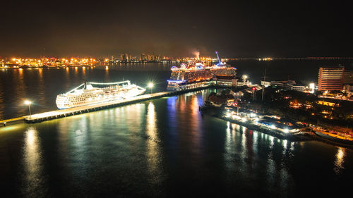 Illuminated bridge over river at night