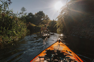 Man kayaking on river against sky