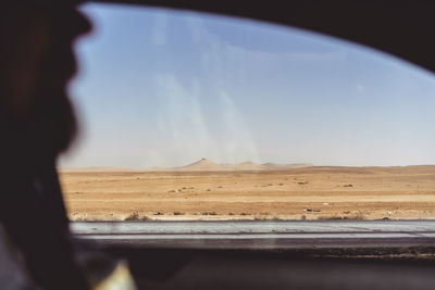 Scenic view of landscape against sky seen through car windshield