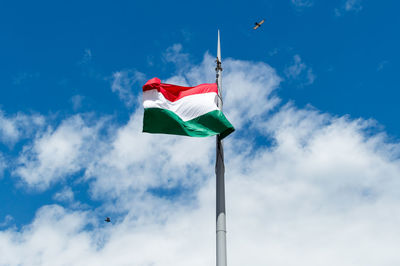 Low angle view of flag flags against sky