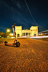 Car on street against illuminated buildings in city at night