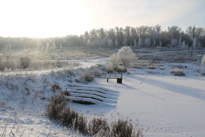 Scenic view of frozen field against sky during winter