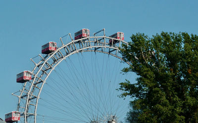 Low angle view of ferris wheel against clear blue sky