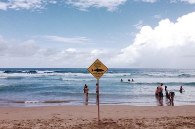 People on beach against sky