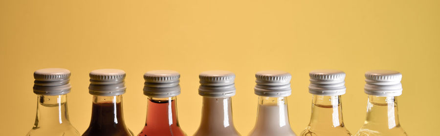 Close-up of yellow bottles against white background