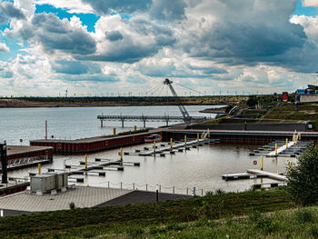 High angle view of sailboats moored at harbor against sky