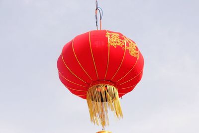 Low angle view of lantern hanging against sky