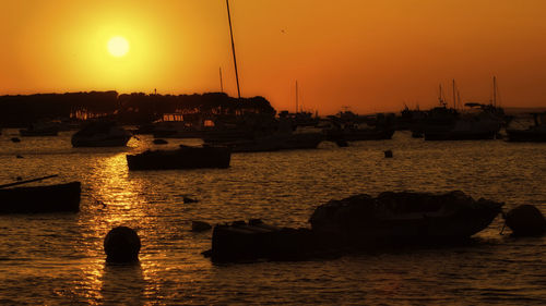 Silhouette sailboats in sea against sky during sunset