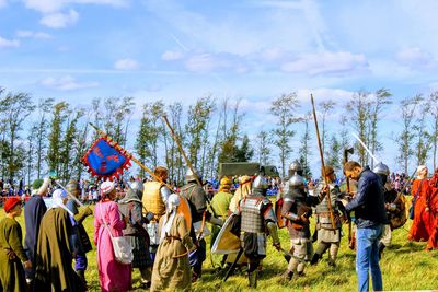 Crowd in traditional clothing against sky